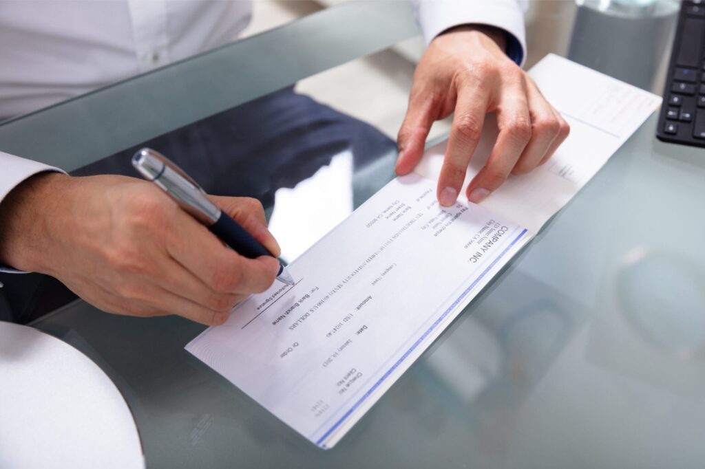 Man writing apprentice incentive payment cheque