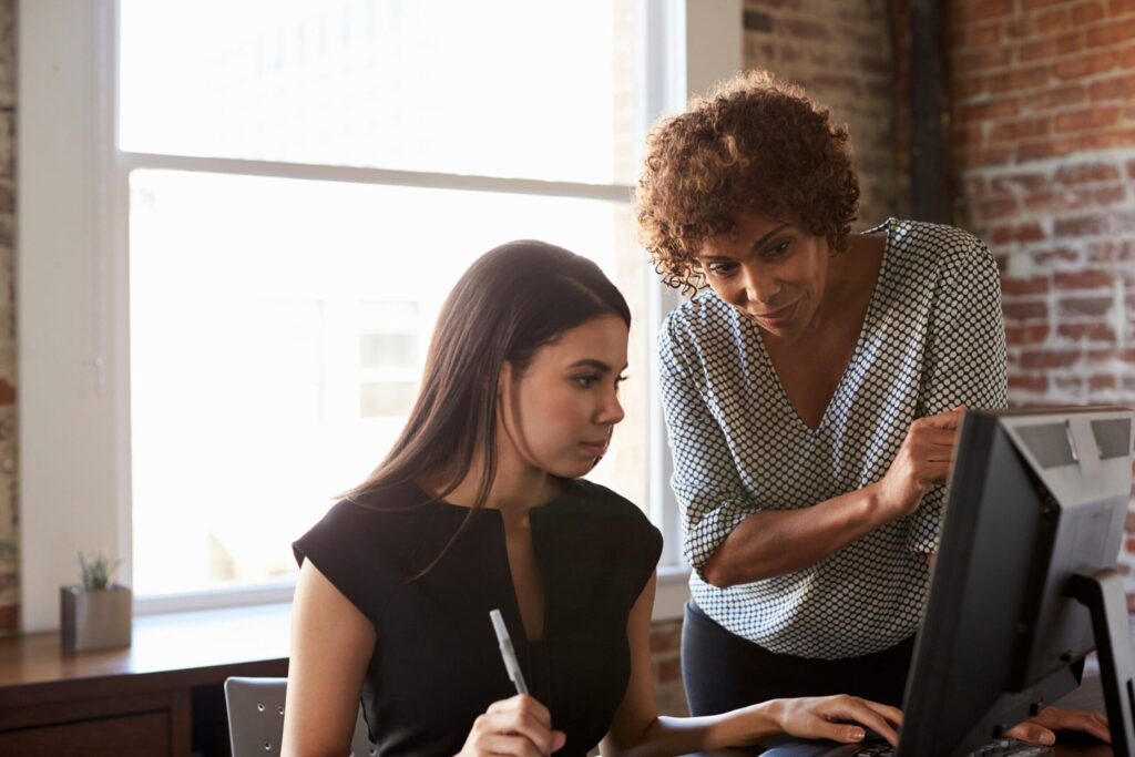 Young female apprentice learning from manager