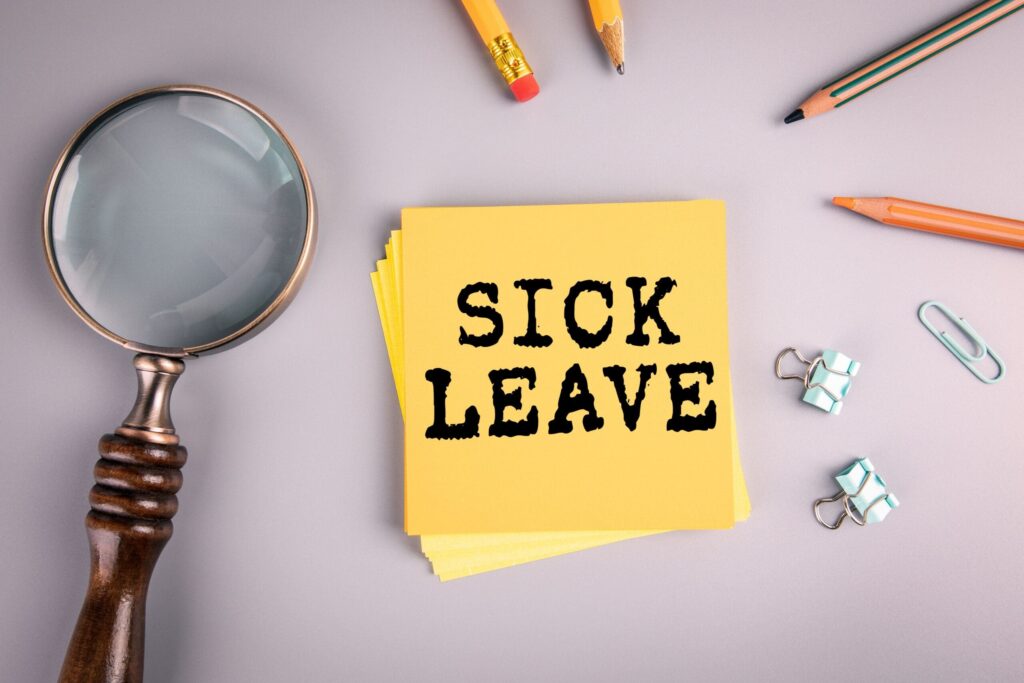 Sick leave sticky note with mangifying glass next to it