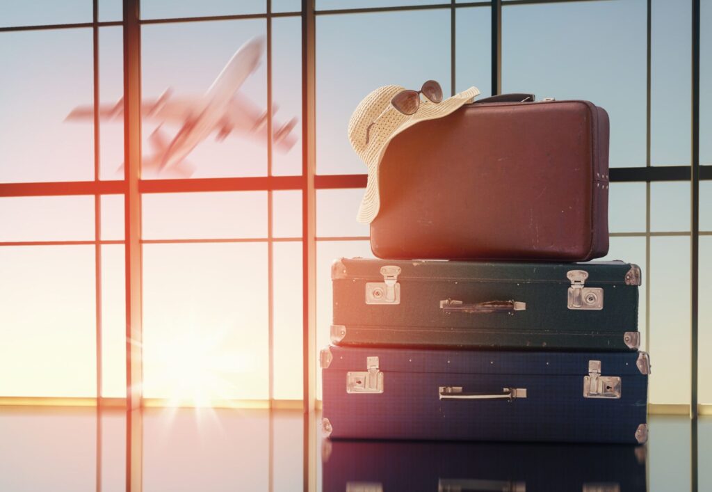 Airport suitcases with plane taking off in background