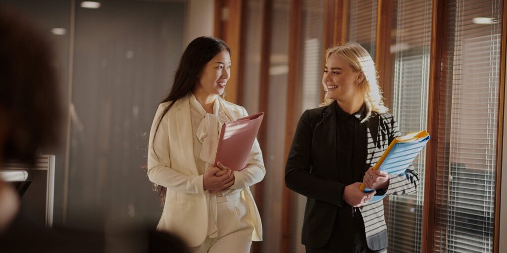 Two people walking, chatting and smiling at each other