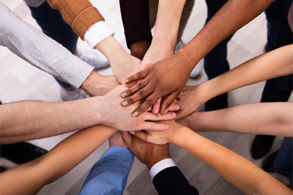 Diverse number of employees putting hands together