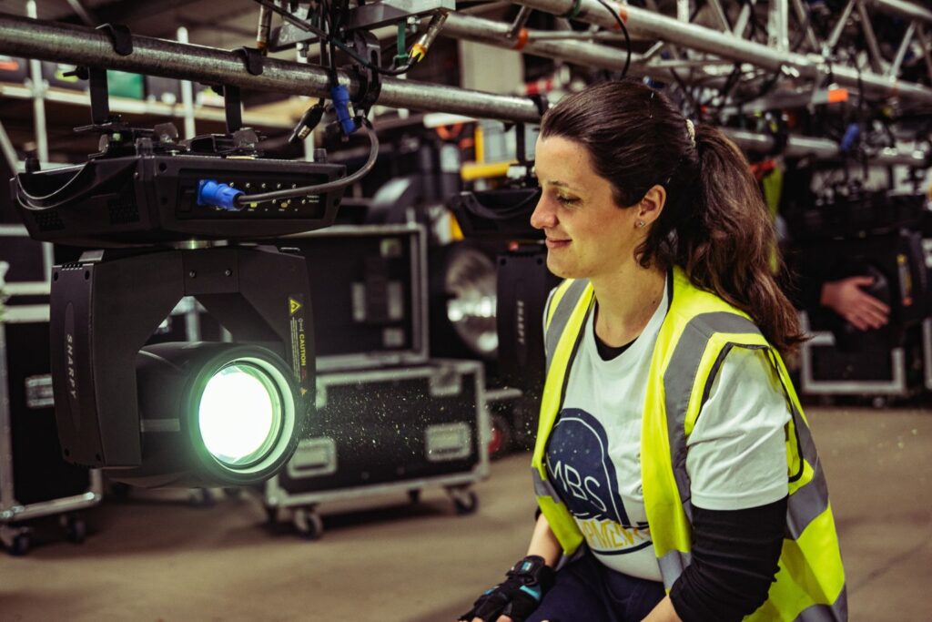 Screen Lighting Technician apprentice with light
