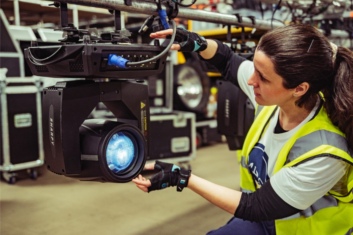 Female apprentice working on a studio light equipment